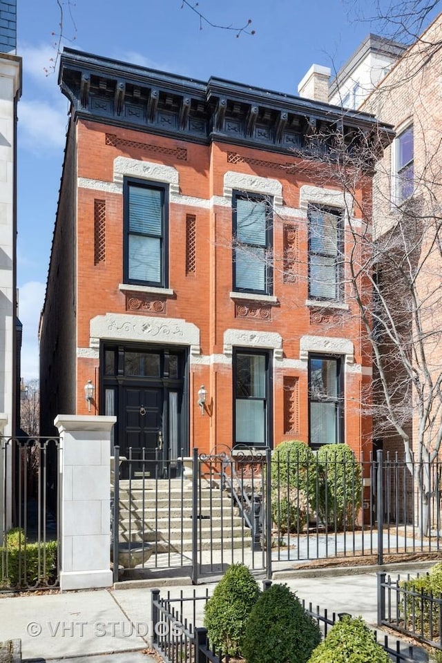 view of front of house with a fenced front yard and brick siding