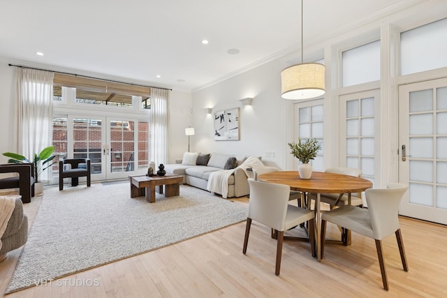 dining space featuring light wood-type flooring, recessed lighting, ornamental molding, and french doors