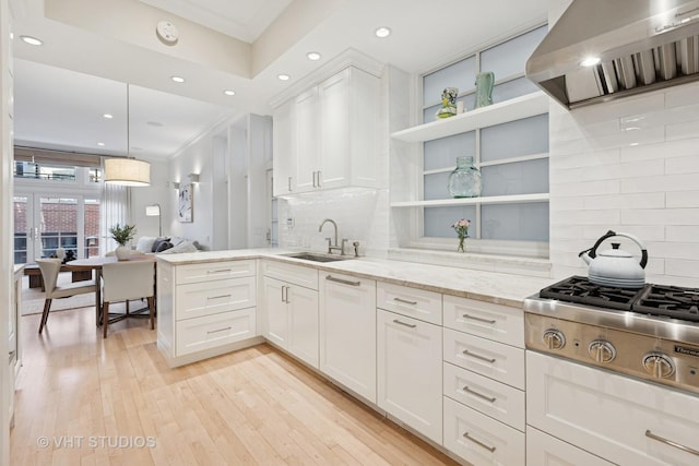 kitchen featuring a sink, open shelves, stainless steel gas stovetop, exhaust hood, and white cabinets