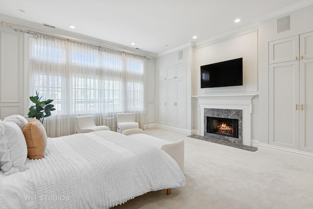 bedroom with carpet flooring, ornamental molding, visible vents, a high end fireplace, and a decorative wall
