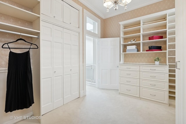 spacious closet with light carpet and a chandelier