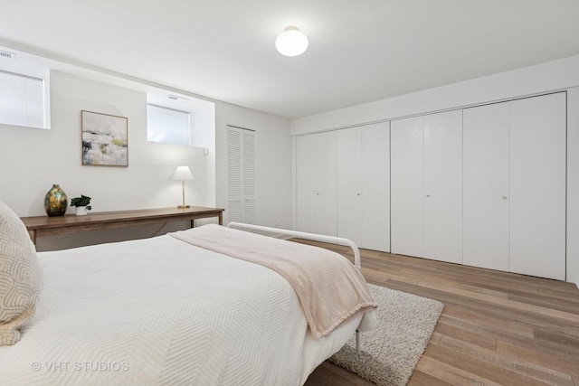 bedroom with visible vents, a closet, and wood finished floors