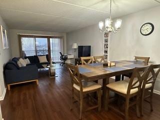 dining room with wood finished floors, baseboards, and a chandelier