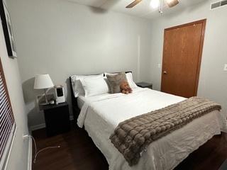 bedroom with visible vents, ceiling fan, and dark wood-style flooring