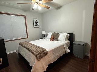 bedroom with baseboards, dark wood-type flooring, and ceiling fan