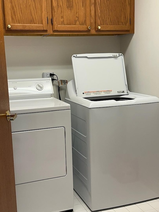 washroom featuring cabinet space and washer and clothes dryer