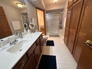 full bath featuring vanity, toilet, visible vents, and a shower with door