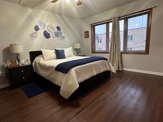 bedroom featuring a ceiling fan, wood finished floors, and baseboards