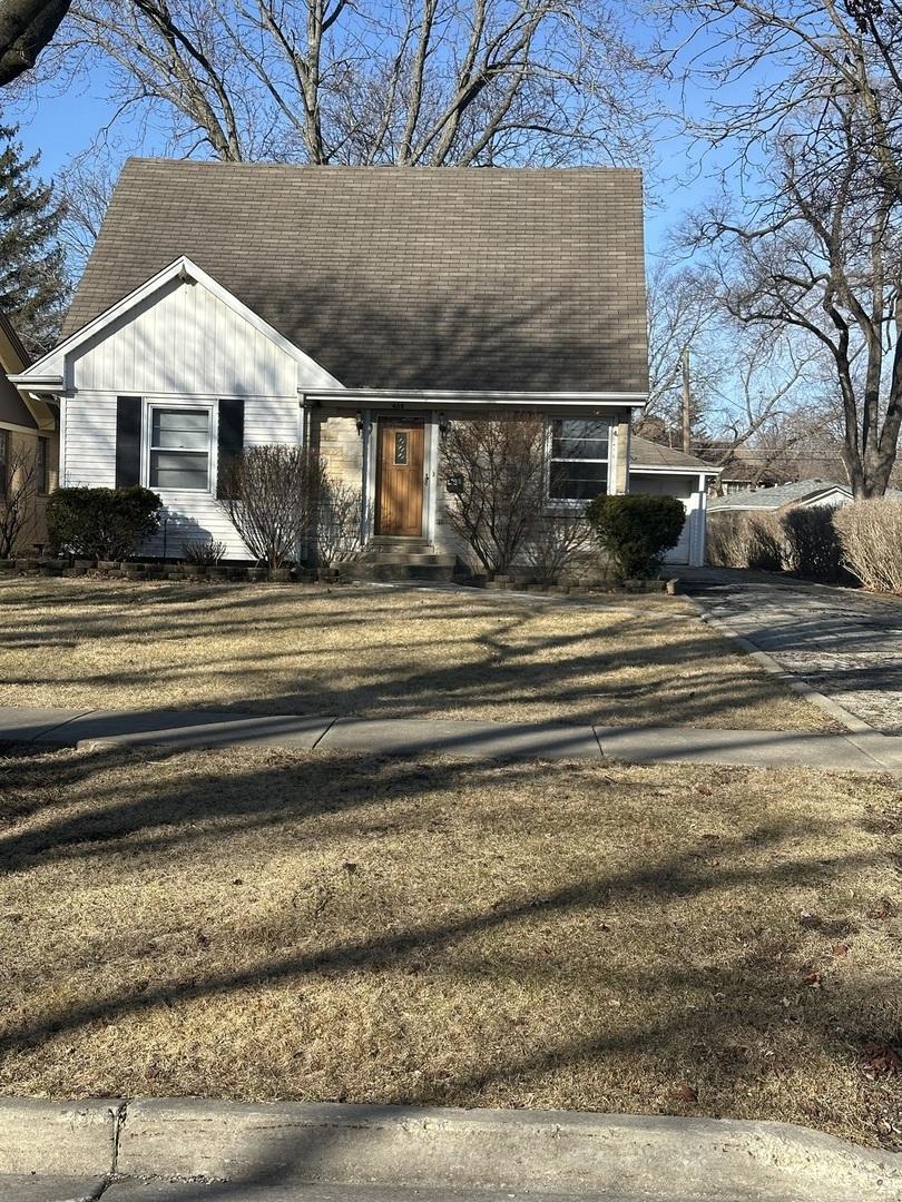 view of front of house featuring a shingled roof, a front yard, driveway, and a garage