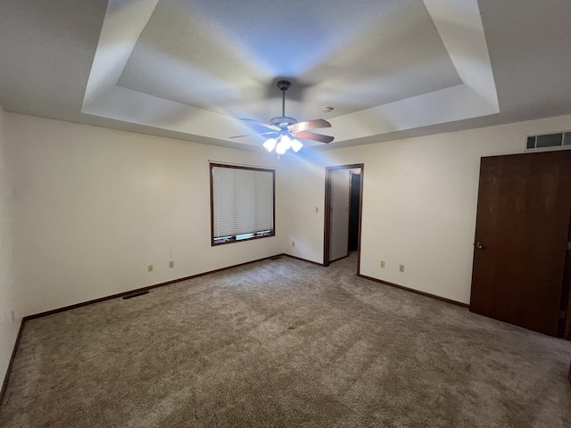 unfurnished bedroom with carpet, a raised ceiling, visible vents, and baseboards