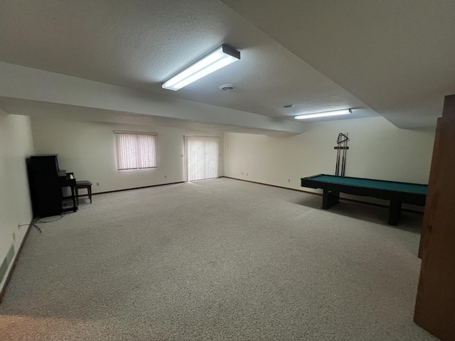 below grade area with carpet floors, baseboards, and a textured ceiling