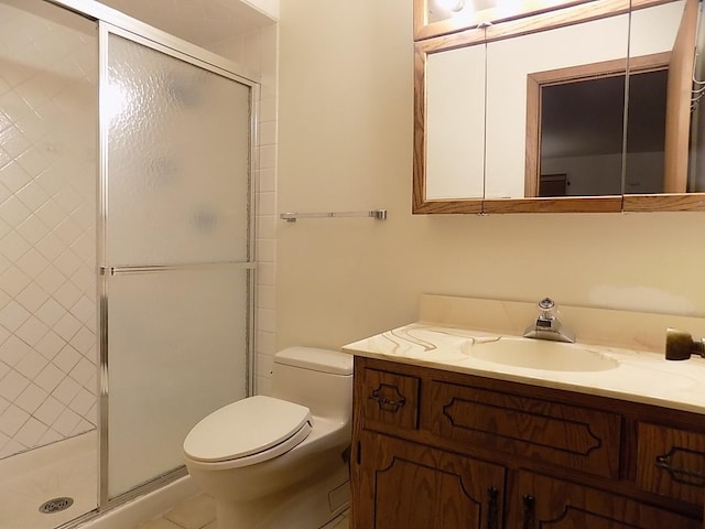 bathroom with a stall shower, vanity, toilet, and tile patterned floors