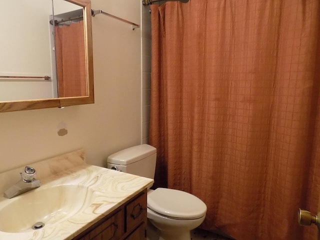 bathroom featuring curtained shower, vanity, and toilet