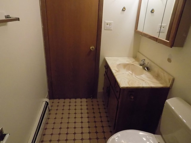 bathroom featuring toilet, baseboard heating, and vanity