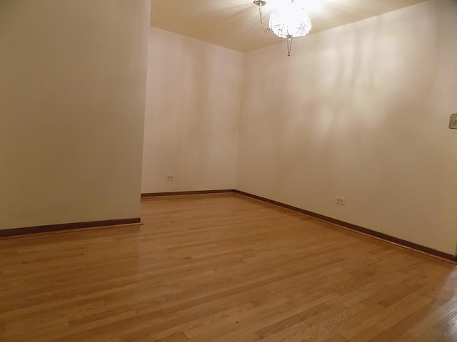 unfurnished room featuring baseboards and light wood finished floors