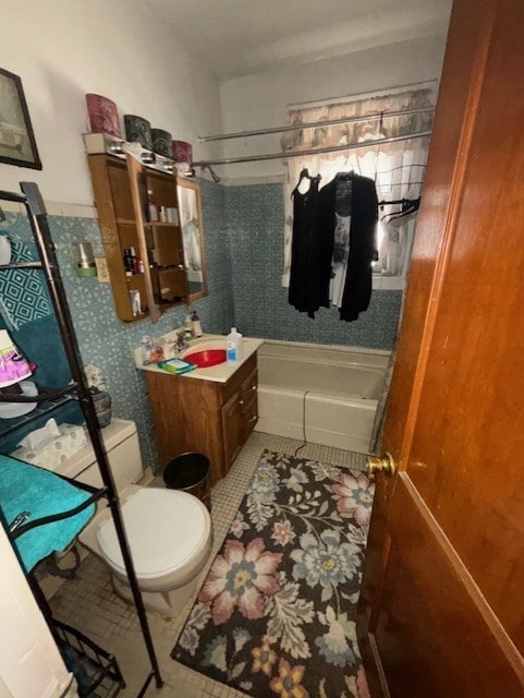 bathroom featuring toilet, tile patterned flooring, washtub / shower combination, and vanity