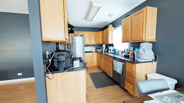 kitchen with stainless steel appliances, dark countertops, and light brown cabinets