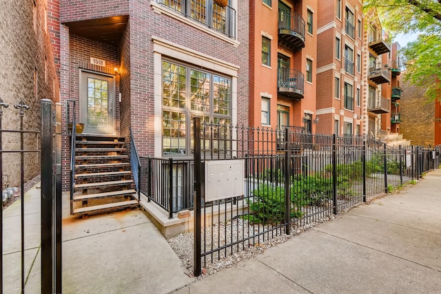 property entrance featuring brick siding and fence