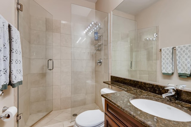 bathroom featuring a shower stall, toilet, and vanity