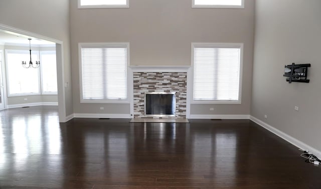 1860 Lake Charles Dr, Vernon Hills, IL 60061 - unfurnished living room with dark wood-style flooring, a towering ceiling, a chandelier, a tiled fireplace, and plenty of natural light