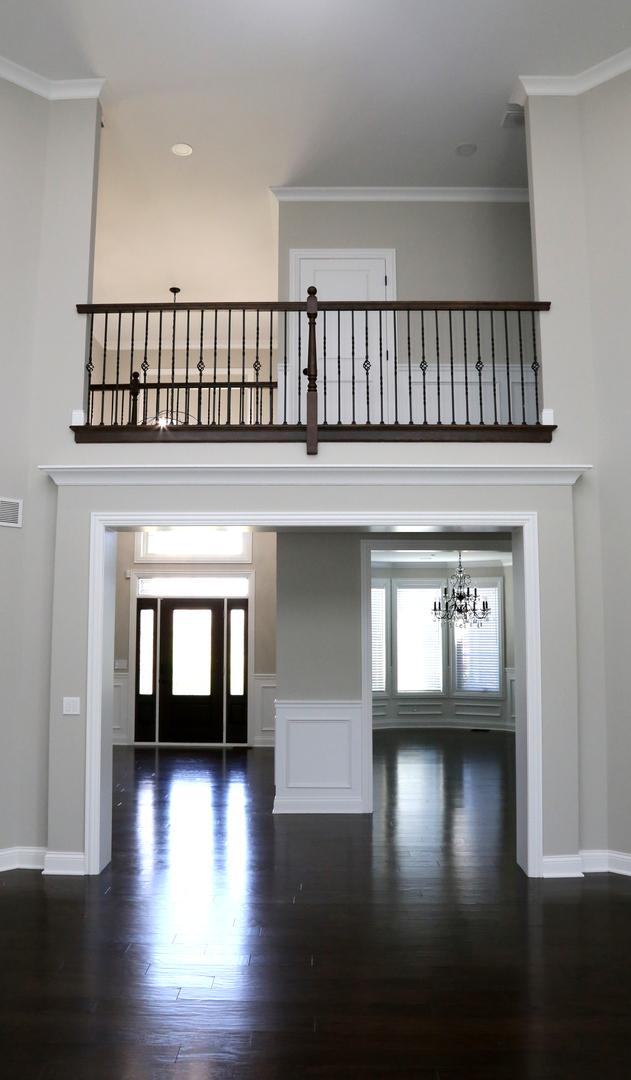 1860 Lake Charles Dr, Vernon Hills, IL 60061 - entrance foyer with a chandelier, crown molding, dark wood-style floors, and a high ceiling