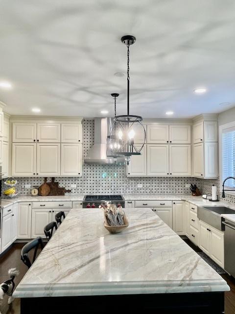 1860 Lake Charles Dr, Vernon Hills, IL 60061 - kitchen featuring wall chimney range hood, a kitchen island, range, decorative backsplash, and light stone counters