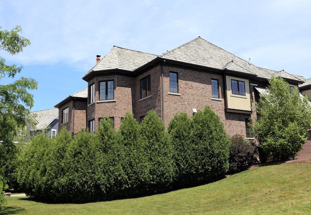 1860 Lake Charles Dr, Vernon Hills, IL 60061 - view of side of home featuring brick siding, a lawn, and a chimney