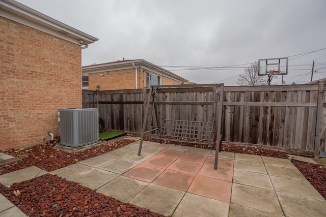 view of patio with central air condition unit and fence