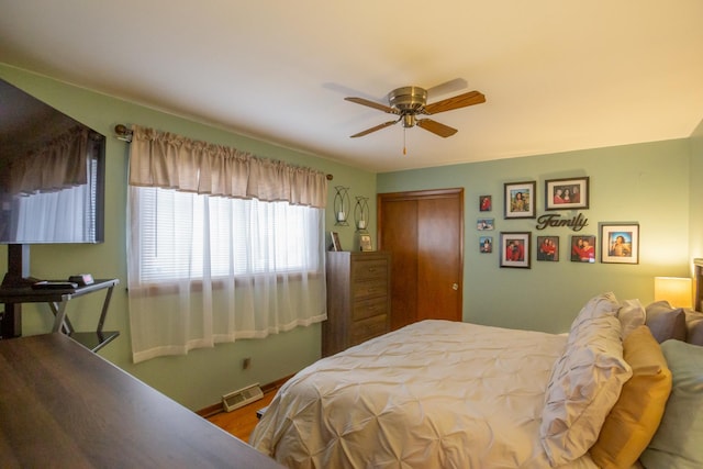 bedroom with a ceiling fan, a closet, visible vents, and baseboards