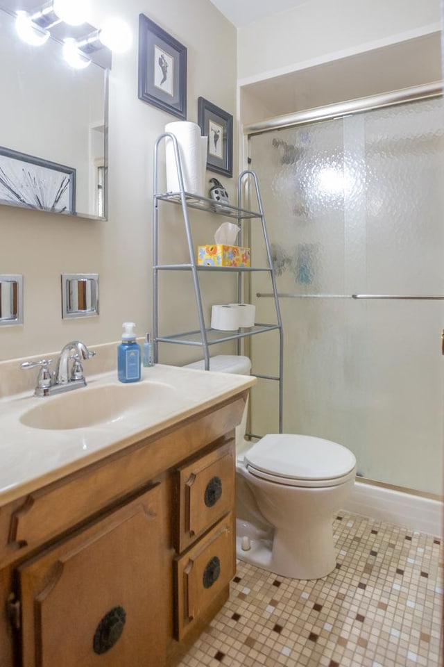 full bathroom with toilet, tile patterned floors, a shower stall, and vanity