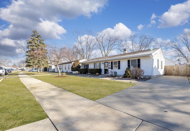 view of front of property featuring a front yard, fence, driveway, and a chimney