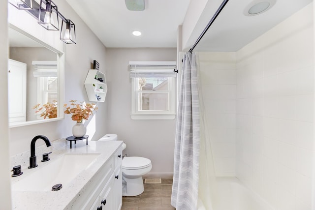 bathroom featuring visible vents, toilet, a healthy amount of sunlight, and wood finished floors