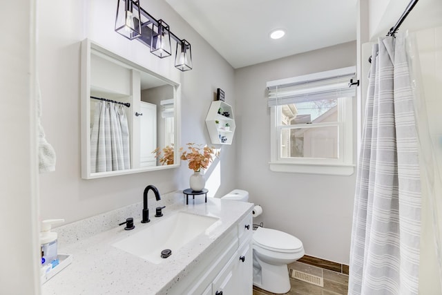 bathroom featuring visible vents, toilet, a shower with shower curtain, baseboards, and vanity