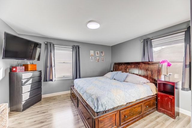 bedroom with baseboards and light wood finished floors