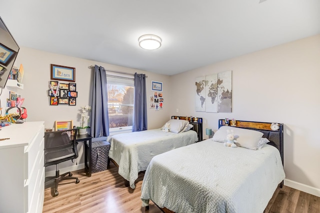 bedroom with baseboards and wood finished floors