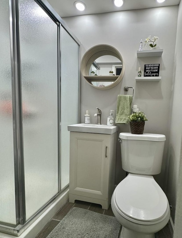 bathroom with toilet, recessed lighting, vanity, a shower stall, and wood tiled floor