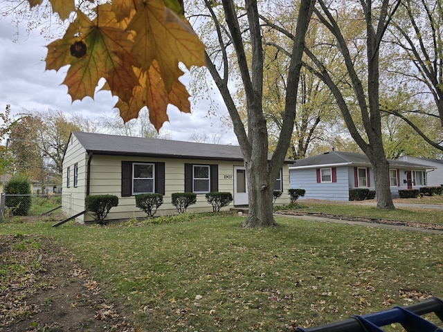 ranch-style house featuring a front lawn and fence