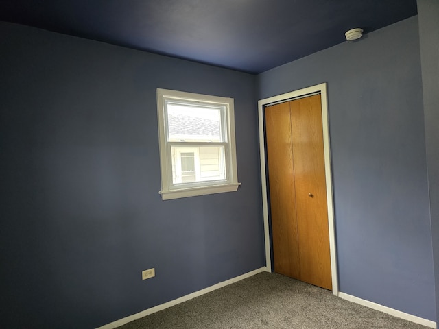 unfurnished bedroom featuring carpet, a closet, and baseboards