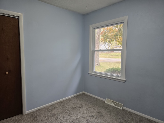 empty room featuring baseboards, visible vents, and carpet flooring