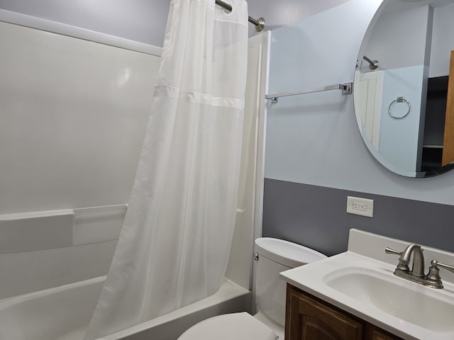 full bathroom featuring toilet, shower / bath combination with curtain, and vanity