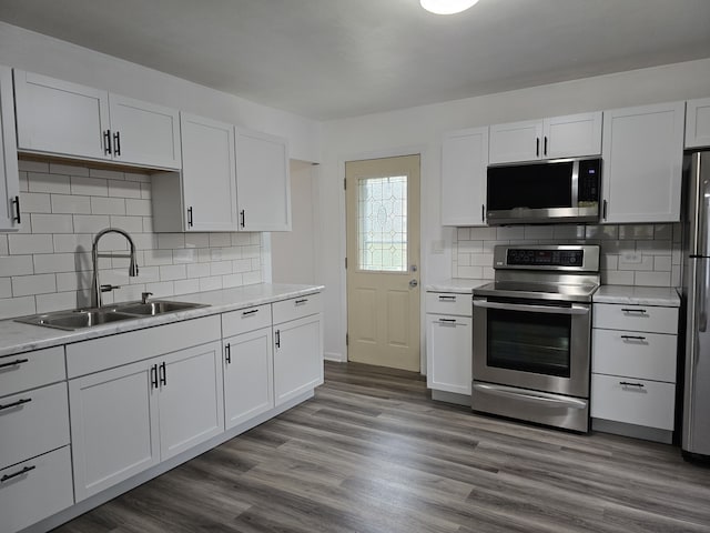 kitchen featuring dark wood-style floors, white cabinetry, appliances with stainless steel finishes, and a sink