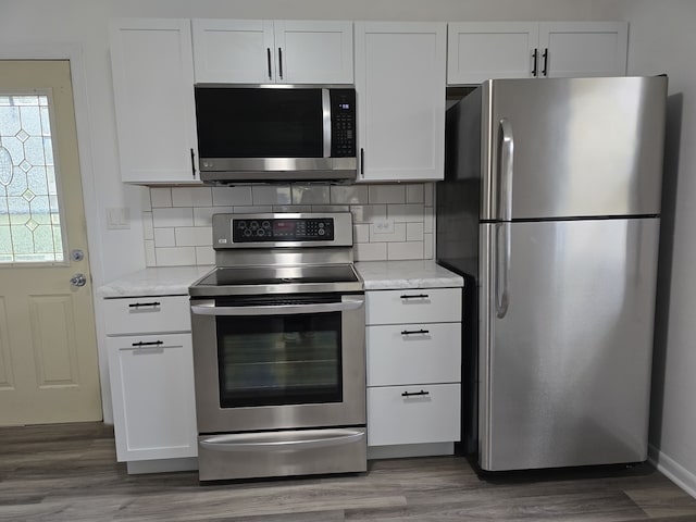 kitchen featuring tasteful backsplash, appliances with stainless steel finishes, light countertops, and wood finished floors