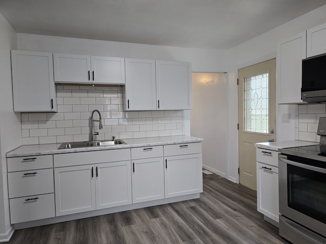 kitchen featuring dark wood finished floors, white cabinetry, stainless steel appliances, and a sink