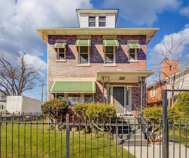 view of front facade featuring a front lawn, brick siding, and a fenced front yard