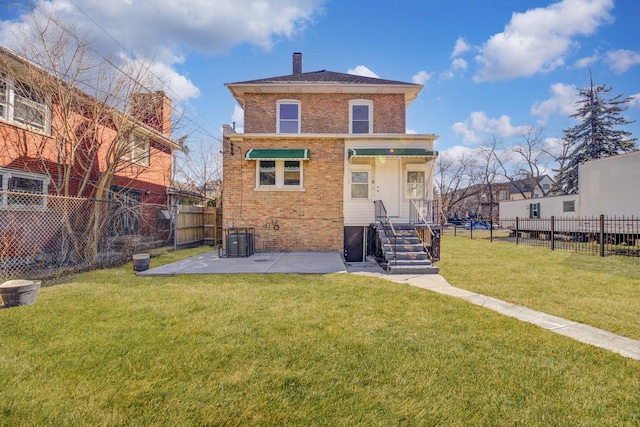 rear view of house featuring brick siding, a lawn, a chimney, and fence private yard