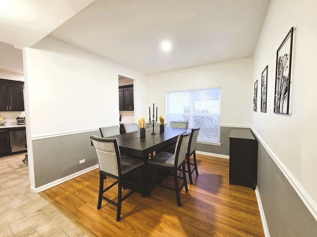 dining space featuring baseboards and light wood-style floors