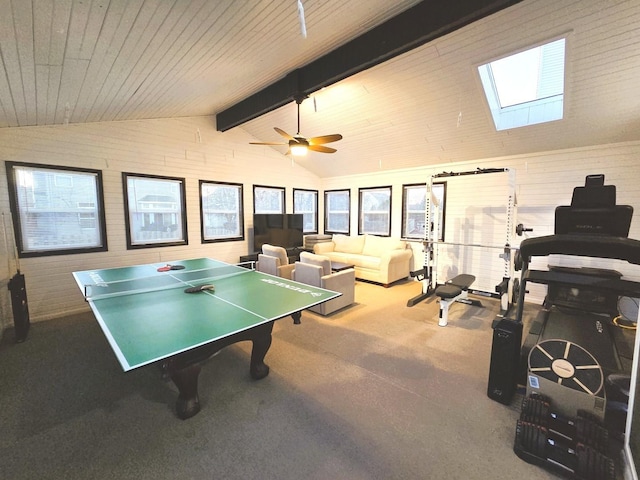 recreation room featuring a ceiling fan, lofted ceiling with skylight, wooden ceiling, and carpet floors