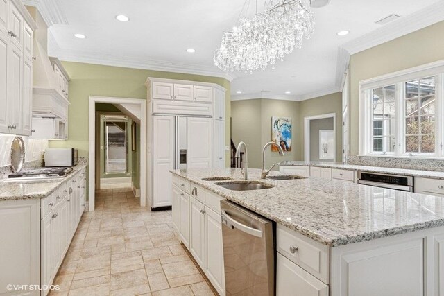 kitchen with stainless steel dishwasher, a sink, white cabinetry, recessed lighting, and a chandelier