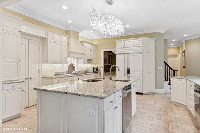 kitchen featuring a sink, appliances with stainless steel finishes, recessed lighting, custom range hood, and a chandelier