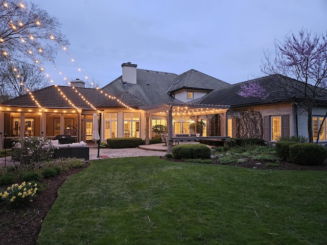 back of property with a pergola, an outdoor hangout area, a yard, a chimney, and a patio